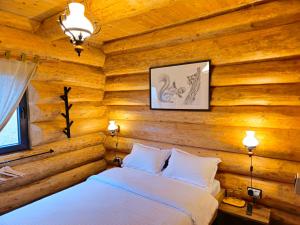 - une chambre dotée d'un mur en bois et d'un lit dans l'établissement Cabana Alaska, à Rânca