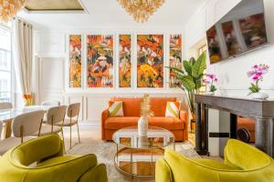 a living room with yellow chairs and a table at Luxury 6 Bedroom 3 Bathroom Louvre Champs Elysees in Paris