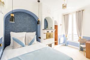Luxury 6 Bedroom 3 Bathroom Louvre Champs Elysees في باريس: غرفة نوم زرقاء وبيضاء مع سرير