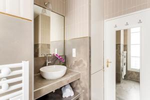 a bathroom with a sink and a mirror at Luxury 6 Bedroom 3 Bathroom Louvre Champs Elysees in Paris