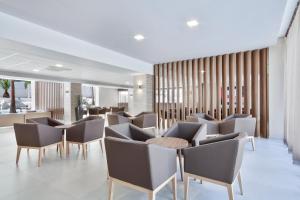 a waiting area with chairs and tables in a building at Hotel Best San Francisco in Salou