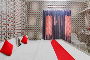 sypialnia z białym łóżkiem z czerwonymi poduszkami w obiekcie Flagship Shri Ram Hotel w mieście Chinhat