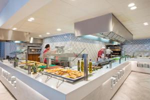 eine Küche, in der Menschen in einem Restaurant Essen zubereiten in der Unterkunft Hotel Best Cambrils in Cambrils