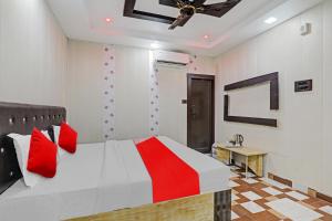 a bedroom with a bed and a ceiling fan at OYO Flagship Ganga Galaxy Hotels And Banquet in Kānpur