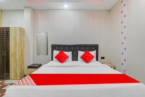 a red and white bed with red pillows on it at OYO Flagship Ganga Galaxy Hotels And Banquet in Kānpur
