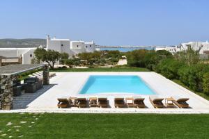 a swimming pool with lounge chairs and a pool at SUNRAY Paros Beach front 2 bedroom house next to kite sports in Kampos Paros