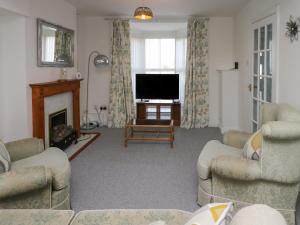 a living room with a television and a fireplace at 23 Beach Road in Y Felinheli