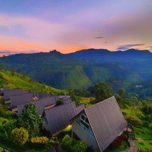 un grupo de casas en las montañas al atardecer en Waterfalls View Resort, en Talawakele