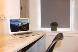 laptopa siedzącego na drewnianym blacie w obiekcie The Arches - The Big Yin w mieście Stirling