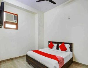 a bedroom with a large bed with red pillows at Hotel Sky Bird in Bhauli