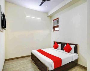 a bedroom with a bed with red pillows at Hotel Sky Bird in Bhauli