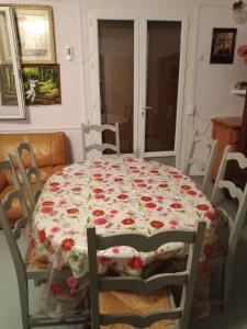 stół jadalny z kwiatowym obrusem w obiekcie Maison complète w mieście Montluçon