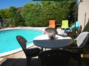 een tafel en stoelen naast een zwembad bij La Saugelia votre maison avec piscine privative ! in Mouriès