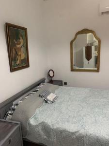 1 dormitorio con 1 cama con espejo en la pared en Παραθαλάσσιο στούντιο με κήπο, en Saronida