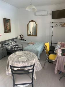 a room with a table and chairs and a bed at Παραθαλάσσιο στούντιο με κήπο in Saronida