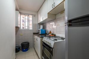 a small kitchen with a stove and a refrigerator at Departamento familiar en Nueva Cordoba by lofty in Cordoba
