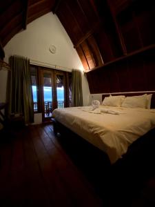 a bedroom with a large bed and a large window at Nawasena Ocean View in Toyapakeh