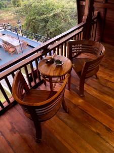una veranda in legno con 2 sedie e un tavolo di Nawasena Ocean View a Toyapakeh
