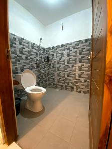 a bathroom with a toilet and a shower at Nawasena Ocean View in Toyapakeh