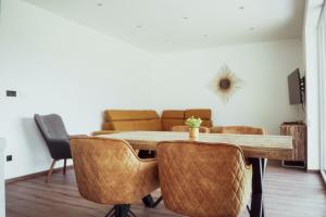 - une salle à manger avec une table, des chaises et un canapé dans l'établissement Fitromax Apartmanház, à Ajka
