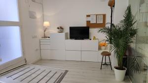 a living room with a tv on a white cabinet at Estudio HortaBCN in Barcelona