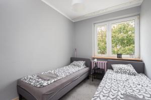 sypialnia z 2 łóżkami i oknem w obiekcie Pokoje Wasilkowskiego w Warszawie