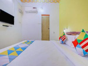 a bedroom with a large bed with a tv on the wall at Flagship Le Pondy Paradise in Puducherry