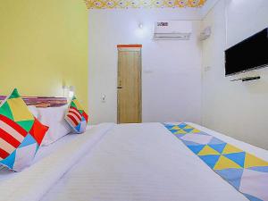 a bedroom with a large bed and a television at Flagship Le Pondy Paradise in Puducherry
