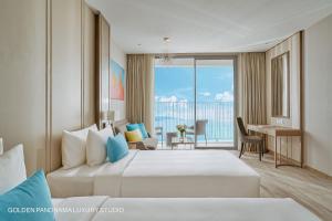 a hotel room with two beds and a view of the ocean at GOLDEN PANORAMA LUXURY STUDIO in Nha Trang