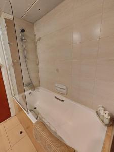 a bathroom with a shower and a white tub at Ευ ζην Central / Ev zen central in Nicosia