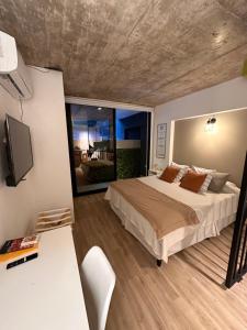 1 dormitorio con 1 cama, escritorio y TV en Departamento BALCARCE en Salta