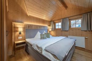 ein Schlafzimmer mit einem großen Bett in einem Holzzimmer in der Unterkunft AlpenParks Hagan Lodge Altaussee in Altaussee