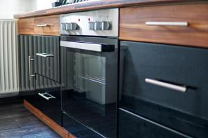 een keuken met een oven en houten kasten bij Homefy Family Apartment mit Netflix in Essen