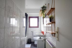 een badkamer met een wastafel, een toilet en een raam bij Homefy Family Apartment mit Netflix in Essen