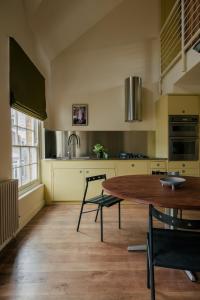 a kitchen with a wooden table and chairs in it at Stylish 1 bedroom in Covent Garden with terrace in London