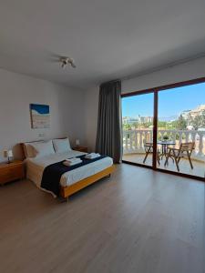 a bedroom with a bed and a balcony with a view at Ευ ζην Central / Ev zen central in Nicosia