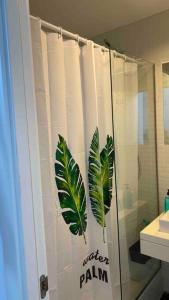 - un rideau de douche avec des feuilles dans la salle de bains dans l'établissement “El SEIS”, à Madrid