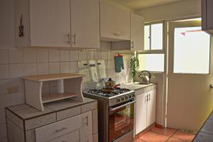 a kitchen with white cabinets and a stove top oven at Mountain Home in Huaraz