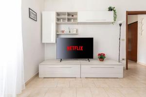 a tv sitting on top of a white cabinet in a living room at [Milano Fiera] Total Relax Pero in Pero