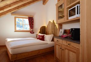 a bedroom with a bed and a counter with a window at Agritur el mas in Moena