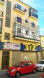 a red car parked in front of a building at CASA MORENO VUT in Ávila