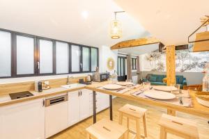 una cucina con armadietti bianchi e ripiani in legno di Peaceful love nest of 40 m in Gentilly a Gentilly