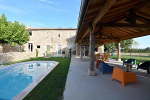 un patio al aire libre con piscina y un edificio en Le Gîte du Taureau en Sainte-Gemme