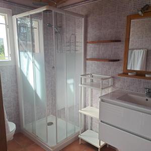 a bathroom with a glass shower and a sink at la chambre de l'auxineill in Castelnou
