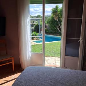 a bedroom with a door open to a swimming pool at la chambre de l'auxineill in Castelnou