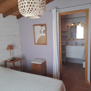 a bedroom with a bed and a bathroom with a tub at la chambre de l'auxineill in Castelnou