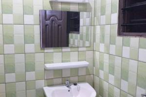 een badkamer met een wastafel en een spiegel bij Ouidah Lodge in Ouidah