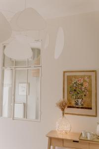 a room with a mirror and a vase on a table at Chez Anne et Grégoire in Voglans