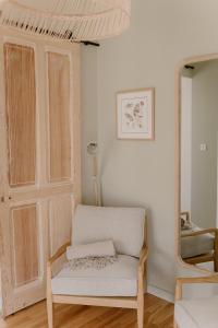 a living room with a chair and a mirror at Chez Anne et Grégoire in Voglans