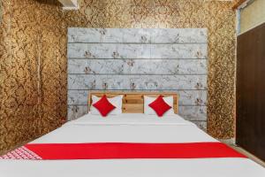 ChinhatにあるFlagship Hotel Sai Palace Near Gomti Riverfront Parkのベッドルーム1室(赤い枕のベッド1台付)